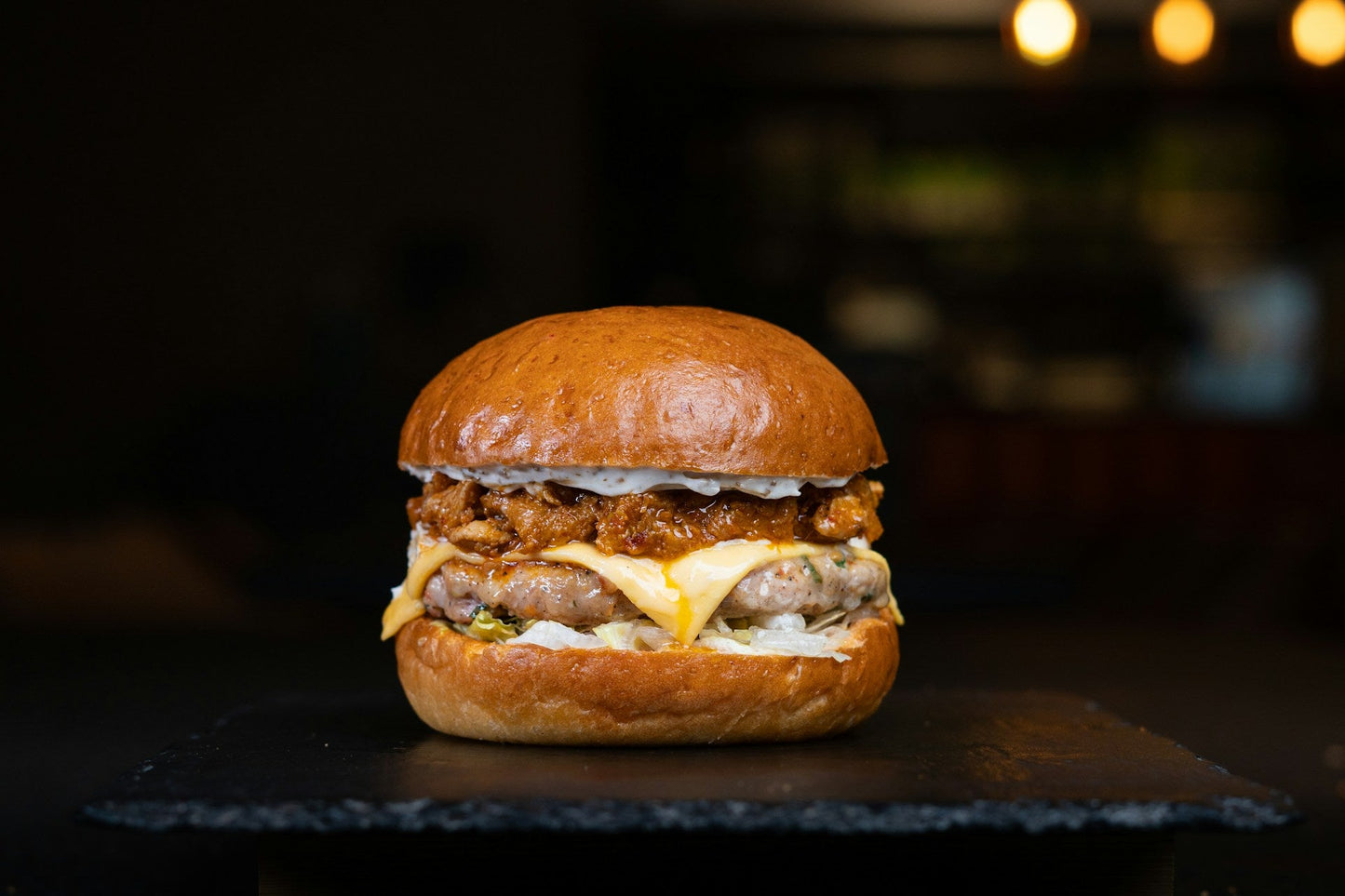 Burger on a brioche bun with melted cheese and lettuce